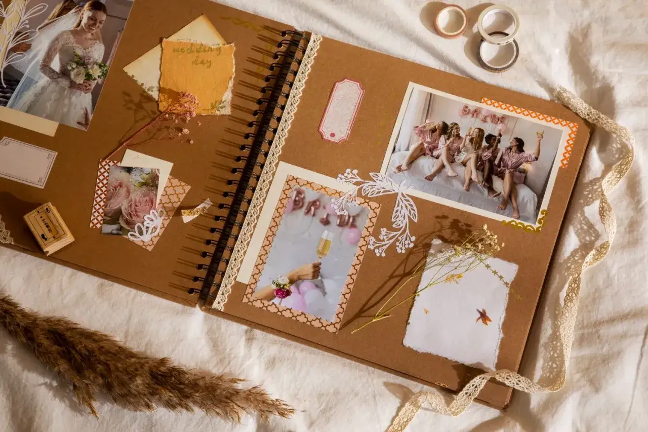 Oto jak wygląda scrapbooking: album z pamiątkami ślubnymi, zdjęciami panny młodej i jej druhen, ozdobiony wstążkami i suszonymi kwiatami.